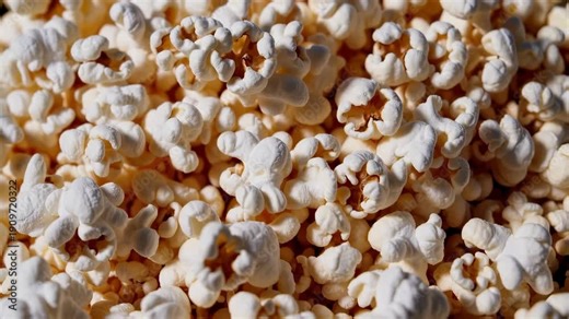 A bright, cinematic moment of popcorn texture. An intense close-up view reveals a full frame popcorn pattern, ideal for entertainment projects and snack-related marketing.