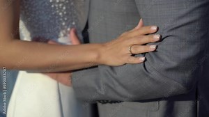The bride and groom are hugging. A young couple in love in a white wedding dress and a grey classic suit. Husband and wife - relationship, family, wedding anniversary or honeymoon.