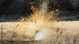 Pumpkin smashing explosive blast slow motion. Pumpkin jackolantern exploding after being shot with a high powered rifle. Rural farm field entertainment. Sharpshooter using a rifle.