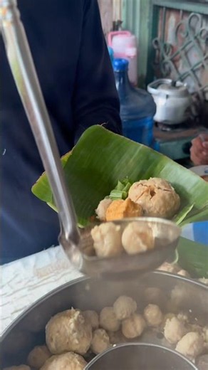 Meatball with mini meatballs inside wrapped in banana leaves