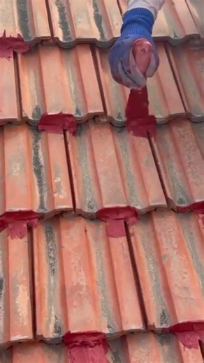 a person is patching a hole in a roof tile