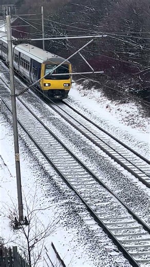 Class 323 passing under a footbridge near Macclesfield