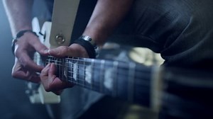 Concert rock band performing on stage with singer performer, guitar, drummer. Music video punk, heavy metal or rock group. Slow motion instrument playing band of men.