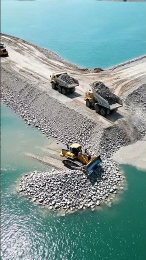 Coastal Rock Embankment Construction with Dump Trucks and Bulldozer