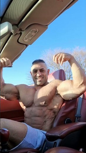 Bodybuilder flexing biceps in his car #bodybuilder #bodybuilding #muscle