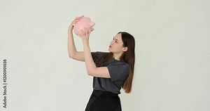 Female student shakes a piggy bank and tests concept of savings Stock Video