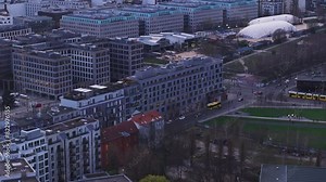 Berlin's dynamic cityscape from a bird's eye view, capturing modern architecture and busy public transportation like its yellow buses