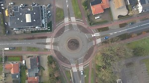 Top down aerial of traffic using roundabout - drone slowly descending and spinning
