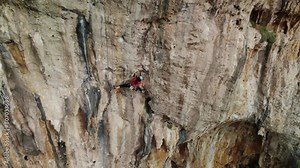 Strong climber climbing a difficult sport climb route in a steep wall at Kalymnos island, Greece. High quality 4k footage.