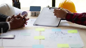 Real estate businessmen discuss with contractor architects to sign contracts for joint construction projects.