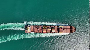 Aerial view Top speed with beautiful wave of container ship full load container with crane loading container for logistics import export or transportation concept background.