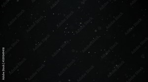 Real dust particles floating in the air on black background. Slow motion.