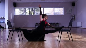 Professional female dancer does a split on two chairs