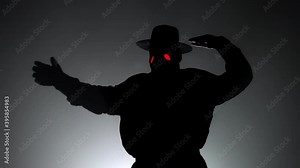Funny meme footage of comic man in plague doctor costume with crow-like mask dancing with hands isolated on black background. Creepy mask, historical costume concept. Epidemic