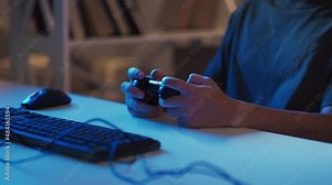 Gaming man. Cyber fun. Night entertainment. Relaxed unrecognizable casual guy playing on computer with console sitting dark light home interior.