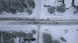 Drone footage of passenger cars driving along beautiful natural landscape. Bird's eye view of traffic in rural road with dense forest and cottages around. High quality 4k footage