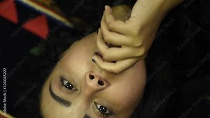 Beautiful smiling teen middle eastern girl wearing black top and relaxing in the bedroom. Portrait of a young middle eastern woman after naps daytime sleep on the bed at home with positive emotions fa