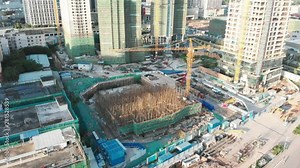 Construction crane pours a pit under the high-rise. Workers install rebar. A new building is being built. Circling the object in a circle. In the background are the same construction. Guangzhou, China