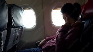 Young woman looking out of the window during plane flight
