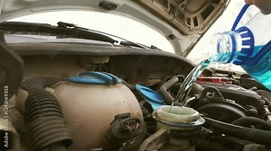 This image shows a closeup of a car engine under the hood, highlighting key components and essential fluid reservoirs important for maintenance and inspection by car owners