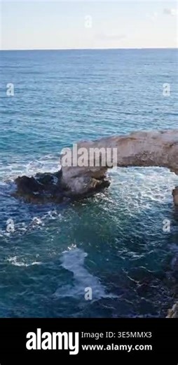Scenic view of the Bridge of Love, a natural rock arch formation in Ayia Napa, Cyprus. Turquoise waves flow beneath the limestone arch Stock Video Footage - Alamy