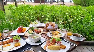 luxury breakfast table on the beach with an ocean view at the tropical Island Koh Kood Thailand, a luxury hotel in Thailand with a breakfast table with bread and eggs, coffee, and juice
