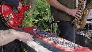 A closeup perspective capturing hands playing a keyboard at an outdoor performance