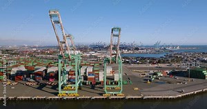 panning view of cranes for loading ships in large container port