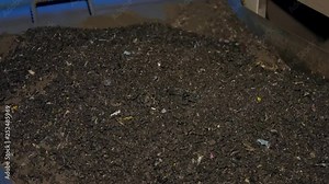 Plastic colored granulated crumb at the plant for processing and casting products from domestic and industrial waste. Closeup tablets of black plastic.