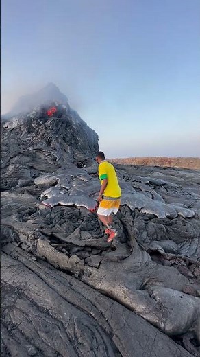 Traveler pokes molten lava as Erta Ale volcano erupts in Afar, Ethiopia