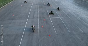 Motorcycle drivers improve their driving skills by driving between traffic cones, aerial view. Motorcycle school.