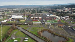 Cinematic trucking drone footage of the Washington State - Puyallup Fair Grounds with barns, roller coasters and carnival attractions and Good Samaritan Hospital in Pierce County, Washington