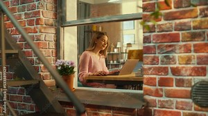 Beautiful Caucasian Girl Using a Laptop Computer while Sitting Behind a Desk in Brooklyn Style Brownstone House. Young Female Browsing Internet, Checking Social Media, Shopping Online.