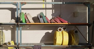 Fire station or engine hose rack for fire emergency or use on truck. Shelves in fire department garage or house with different size and length water hoses. Special heavy duty and high pressure gear