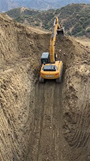 Heavy machinery at work. A Sany tracked excavator navigating a steep incline during excavation