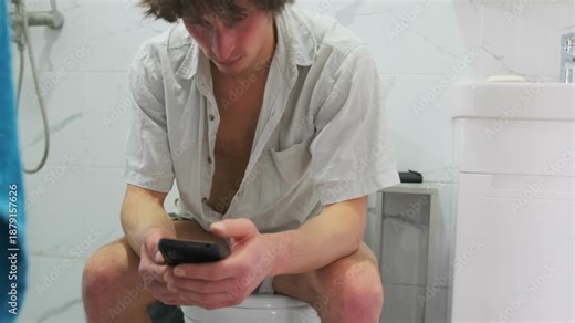 Person peacefully reading messages indoor, Someone quietly relaxing on toilet while checking messages on device, Person is calmly seated in bathroom reading messages on their device peacefully