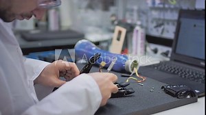 A scientist engineer creates or diagnoses a robotic arm prosthesis. Prosthetic laboratory, industrial production. A mechanical arm for a fulfilling life. Creation of cybernetic limbs.