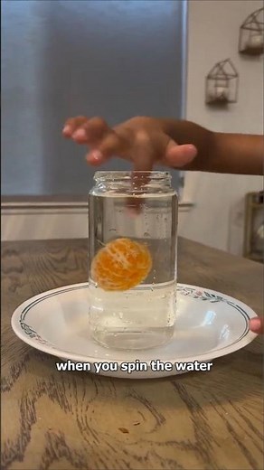 How does spinning water make the orange rise to the surface?