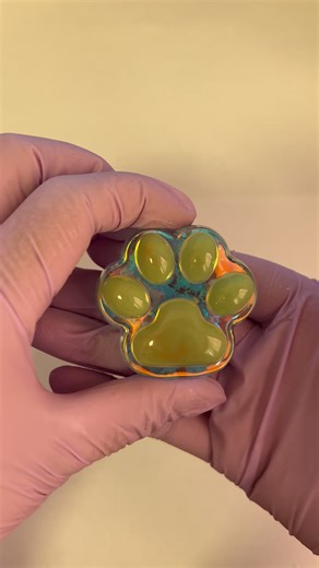 Capturing a gravitational lensing event through a feline-mass green lens. 🔭🌌 This clear resin is the Undisturbed Space-Time Medium. The star and circle glitter inside are distant celestial bodies. The green paw isn't a patch of color—it's a Feline-Mass Gravitational Lens, a dense, green curvature of space that bends the light from those bodies, creating arcs, duplicates, and this unique lensed snapshot. You're not holding glitter in resin. You're holding a focused anomaly, a wearable proof tha