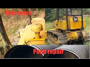 John Deere 450C dragging pipe and cutting new drainage ditch