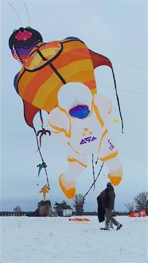 Adding a giant astronaut to a stack of Maxi kites. #KiteFlying #KiteFestivals