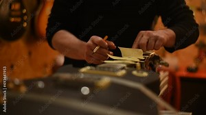 Guitar luthier hands polishes the frets on the fretboard