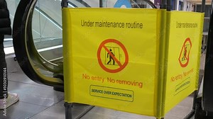 Closed escalator with sign - under maintenance. Equipment maintenance, warning sign, closed path.