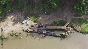 Haitian women washing clothes in waters of Massacre River. Border between Haiti and Dominican Republic. Aerial top-down directly above