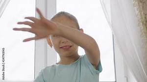 Cheerful girl dancing front camera on room window background backlit natural light. Portrait happy girl teenager having fun makes face grimace and showing tongue while dancing crazy dance