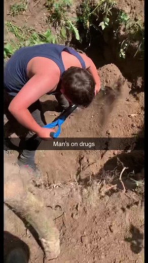 Man Digging a Hole Outdoors with a Shovel