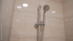 Shower head with wall background in modern bathroom. Shower with water flowing from it in a hotel room. View of a shower with water flowing from it.
