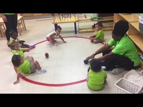 Toddlers rolling the ball lesson