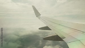 Plane flight in a thunderstorm, thunderclouds. View from porthole onto the wing of airplane flying between the lower and upper layers of the atmosphere, plane window view