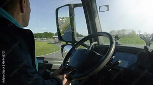 Inside of Cabin View of the Professional Truck Driver Driving His Big Vehicle on the Road. Industrial Warehouses are Seen out of the Window. Shot on RED EPIC-W 8K Helium Cinema Camera.